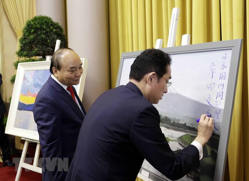 Thủ tướng Nhật Bản Kishida Fumio ký tặng Chủ tịch nước Nguyễn Xuân Phúc tác phẩm hội họa của họa sỹ Việt Nam về phong cảnh Nhật Bản. (Ảnh: Thống Nhất/TTXVN)