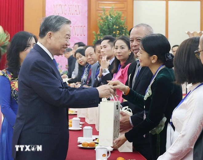 Tổng Bí thư Tô Lâm tặng quà cho kiều bào tiêu biểu tham dự chương trình "Xuân quê hương" năm 2025. (Ảnh: Thống Nhất/TTXVN)