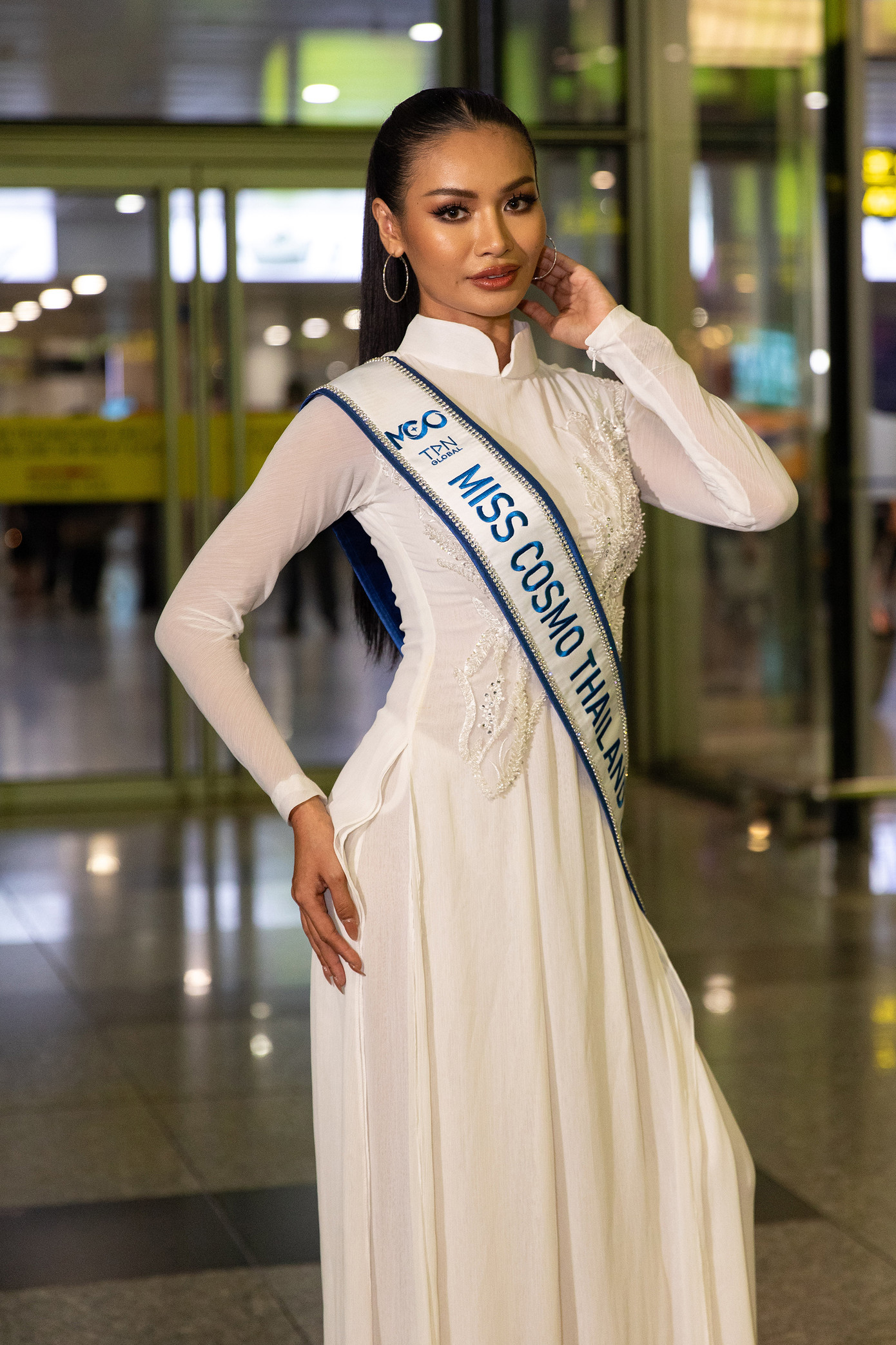 Đại diện Thái Lan gây chú ý khi xuất hiện ở sân bay trong bộ áo dài trắng nền nã. Cô được đánh giá là thí sinh tiềm năng của khu vực châu Á.