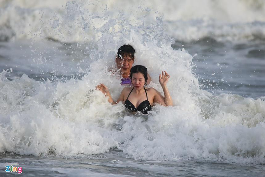 Du khách vui đùa, tận hưởng các con sóng dưới tiết trời nắng nhẹ.