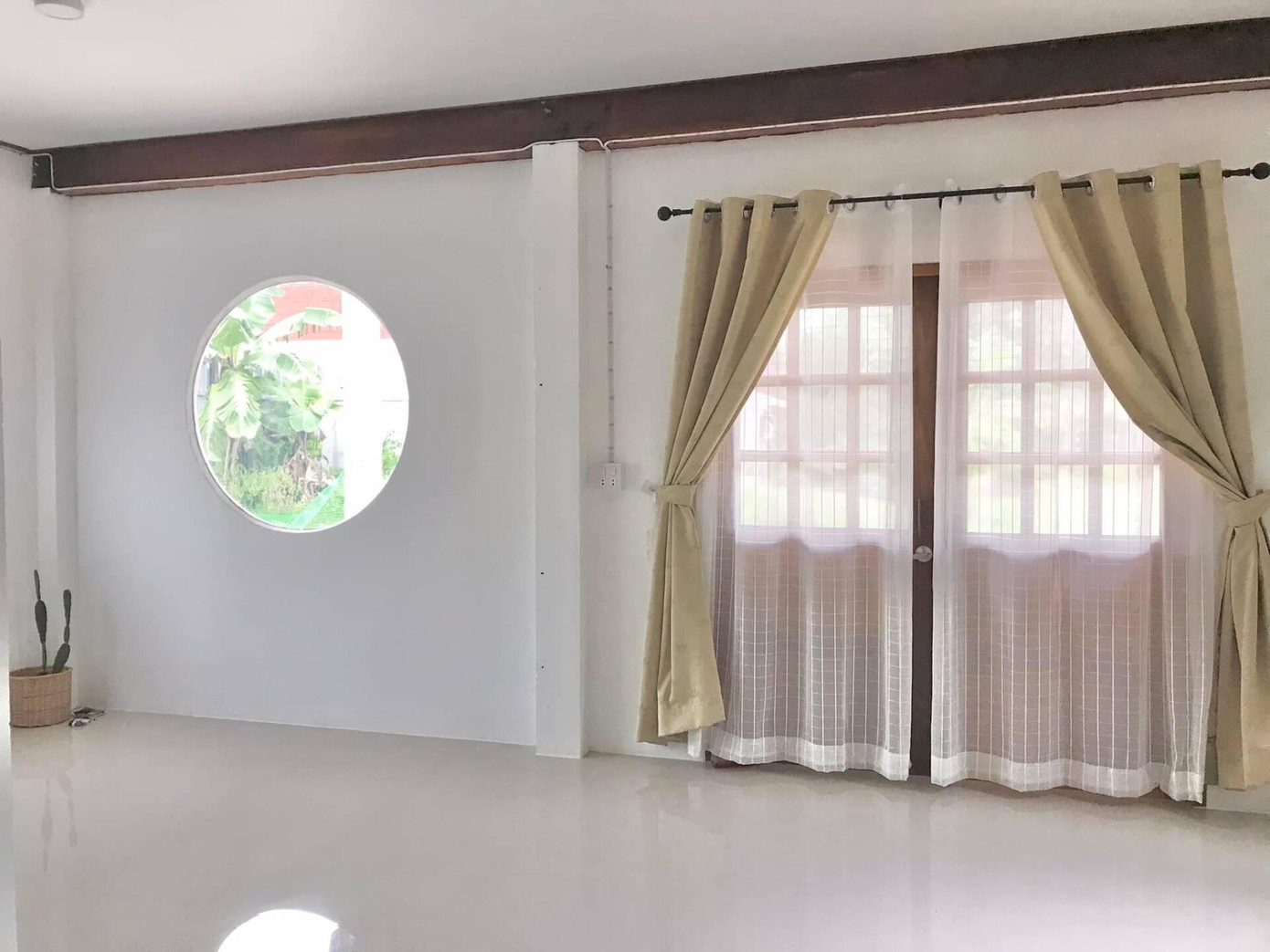 Cửa sổ được bo tròn và lắp kính trở thành một điểm nhấn ấn tượng cho ngôi nhà.