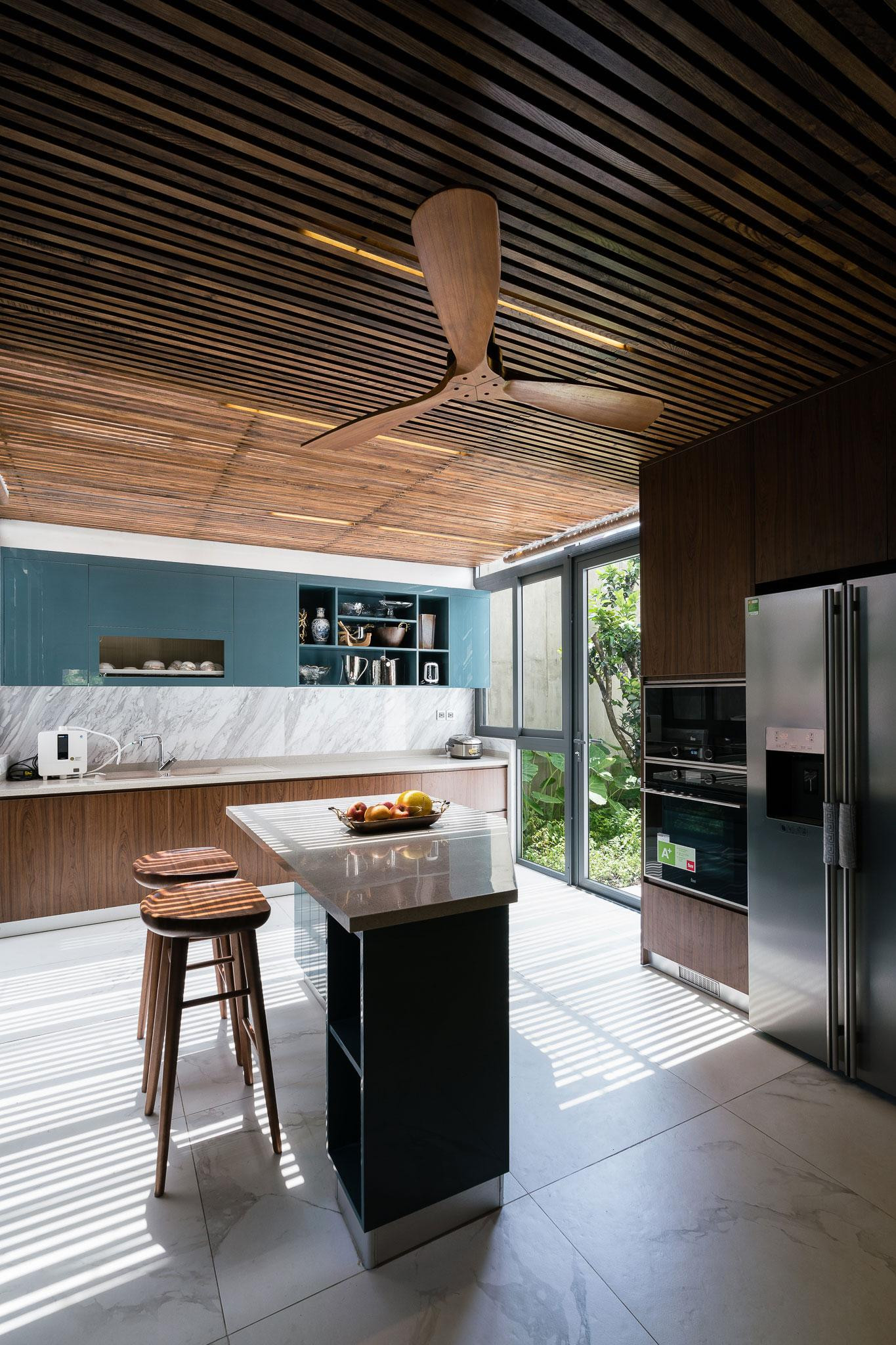 Khu vực ăn uống và bếp đều có tầm nhìn thoáng ra vườn. Vật liệu trong bếp dễ lau chùi và bảo dưỡng. Bộ bàn ăn phù hợp với việc sử dụng gỗ cho trần và sàn.