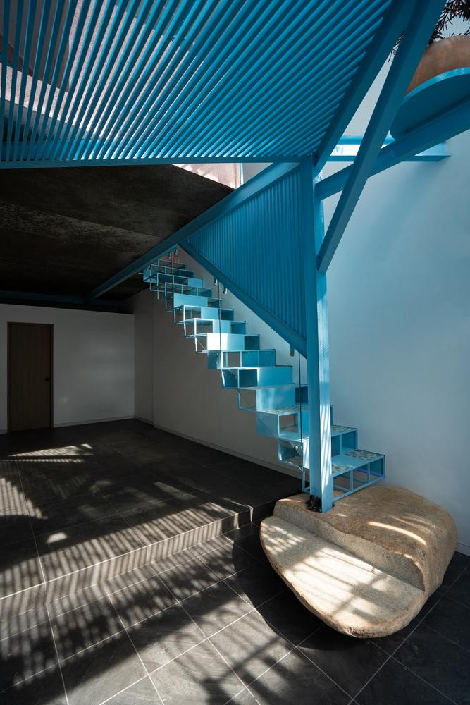 Giếng trời bên trên cầu thang lỗ sắt giúp mọi không gian trong nhà luôn tràn ngập ánh sáng vào ban ngày.