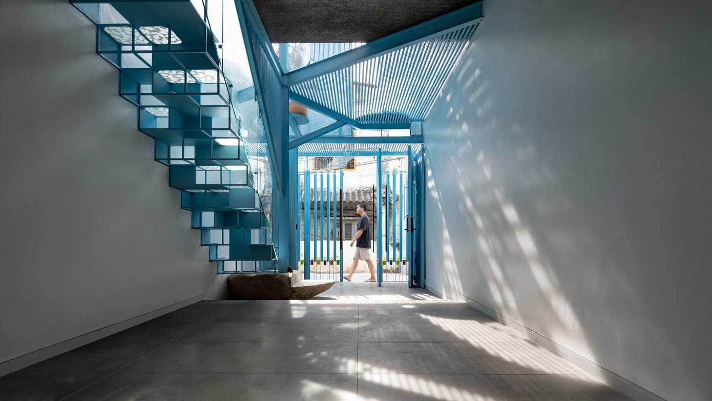 Để thông gió và tăng độ nhận diện cho ngôi nhà, kiến trúc sư sử dụng cửa sắt lỗ màu xanh.