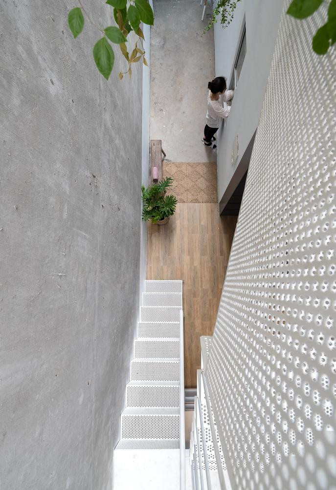 Kiến trúc sư sử dụng cầu thang sắt lỗ để kết nối tầng trệt với tầng 2 mà không làm cản trở tầm nhìn và đường đi của ánh sáng trong nhà vào ban ngày. Kiến trúc sư sử dụng cầu thang sắt lỗ để kết nối tầng trệt với tầng 2 mà không làm cản trở tầm nhìn và đường đi của ánh sáng trong nhà vào ban ngày.