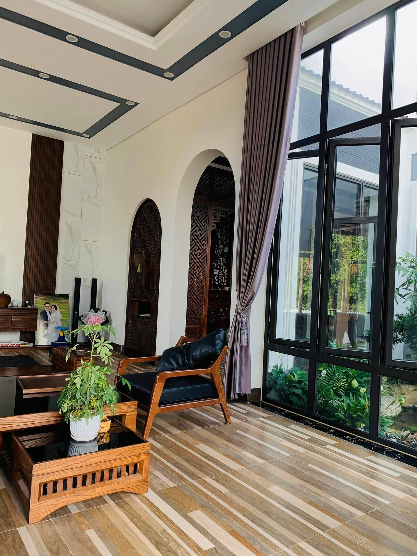 Không gian phòng khách ngập tràn ánh sáng và có tầm nhìn ra khu vườn nhờ các ô cửa kính.