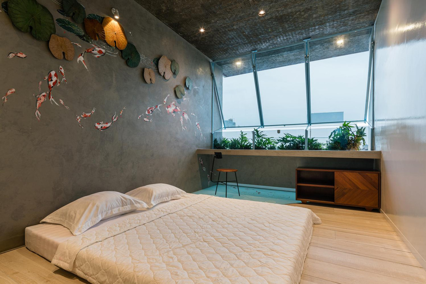 Phòng ngủ có một bàn làm việc bên cạnh cửa sổ kính lớn.