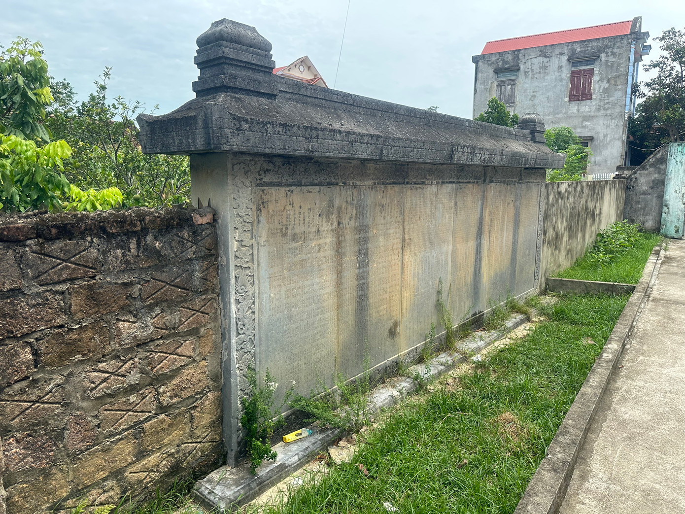 Tấm bia lớn được làm tường rào của nhà dân.