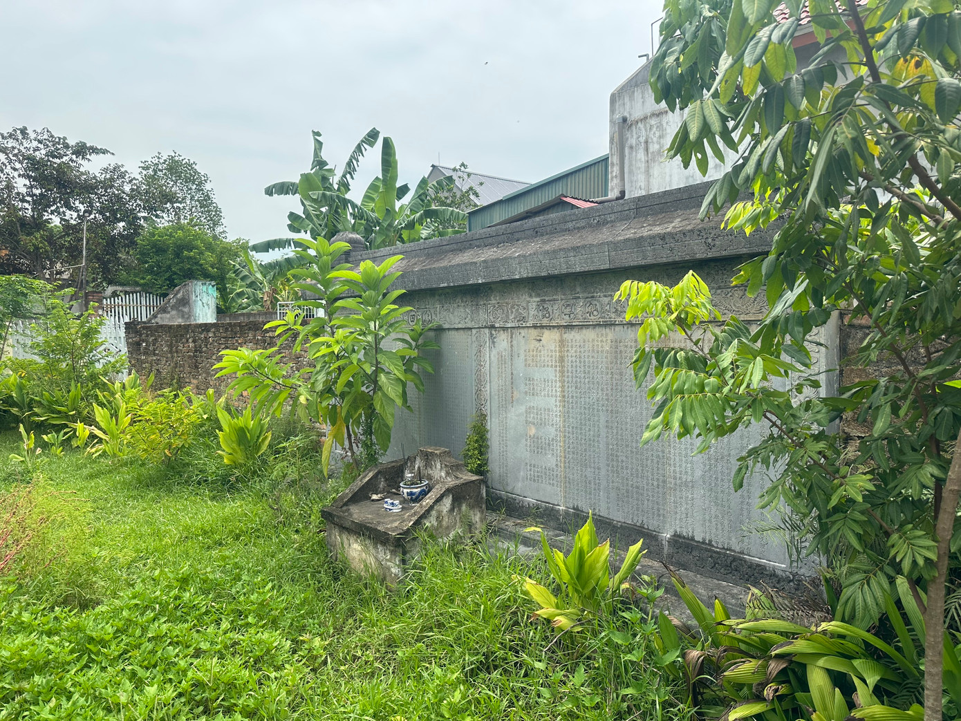 Một bên của tấm bia quay vào khu vườn của nhà dân.