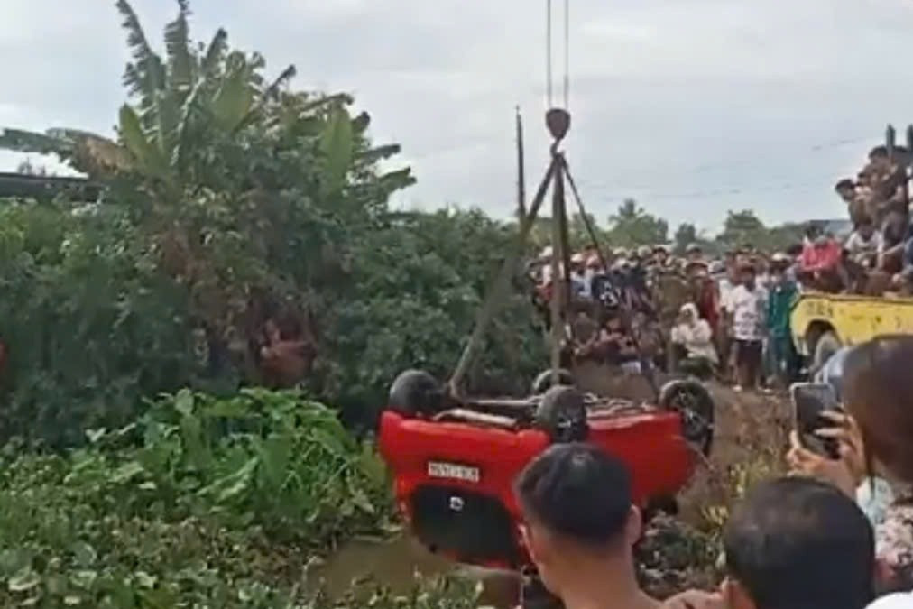 Ô tô rơi xuống kênh được lực lượng chức năng trục vớt lên bờ. Ảnh: MĐ.