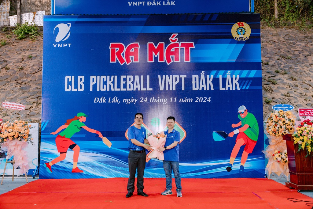 Chủ nhiệm CLB Pickleball VNPT Đắk Lắk Bùi Văn Phúc (phải) nhận hoa chúc mừng từ Phó Giám đốc Nguyễn Văn Thản