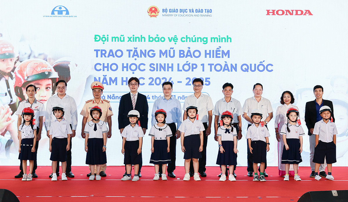 Các đại biểu trao tặng mũ bảo hiểm cho các em học sinh lớp Một trường Tiểu học Tiểu La, quận Sơn Trà, Đà Nẵng