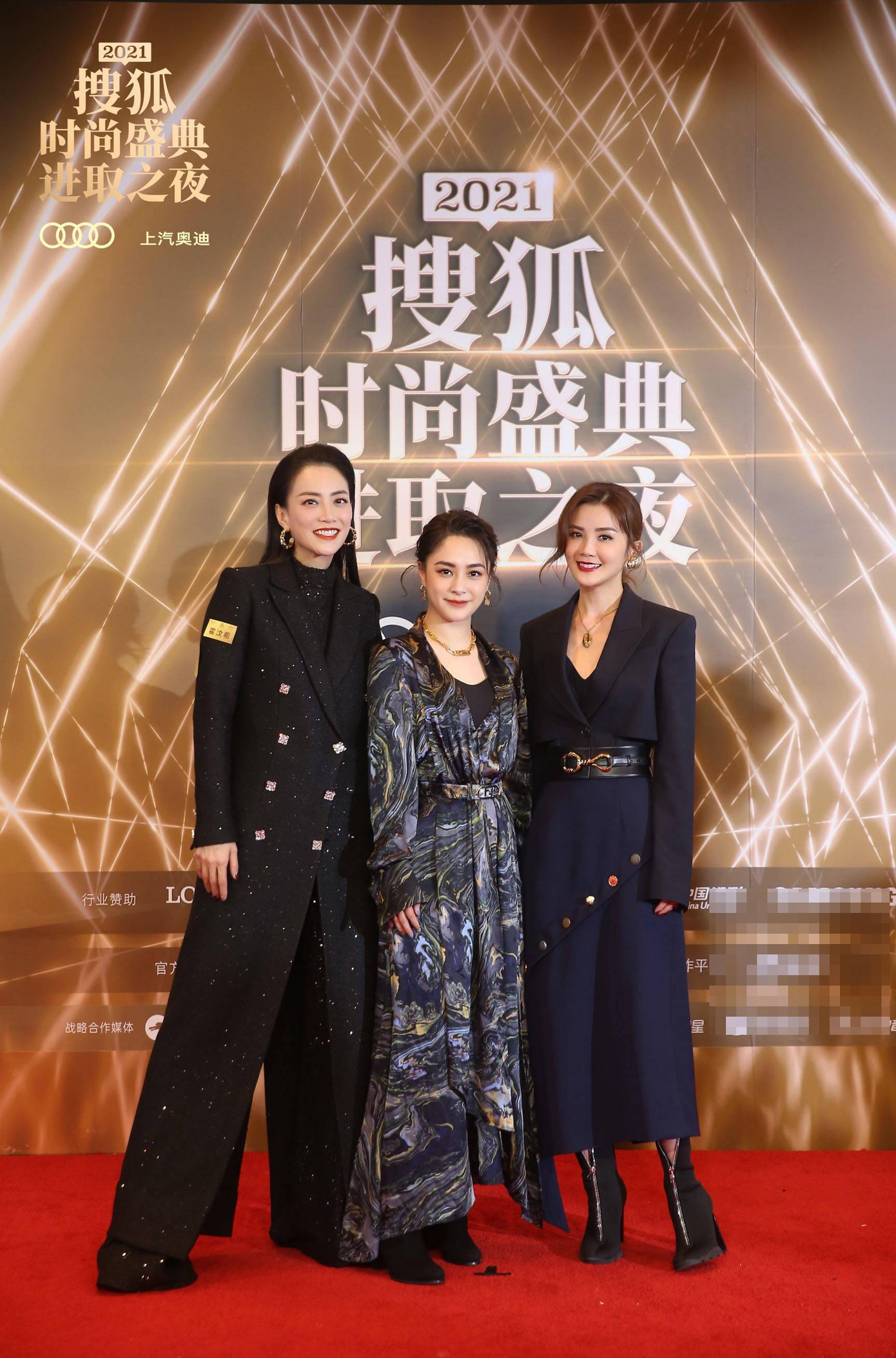 Hai thành viên nhóm nhạc Twins Chung Hân Đồng (giữa) và Thái Trác Nghiên (phải) đi thảm đỏ cùng nhà sản xuất phim Mani Fok.