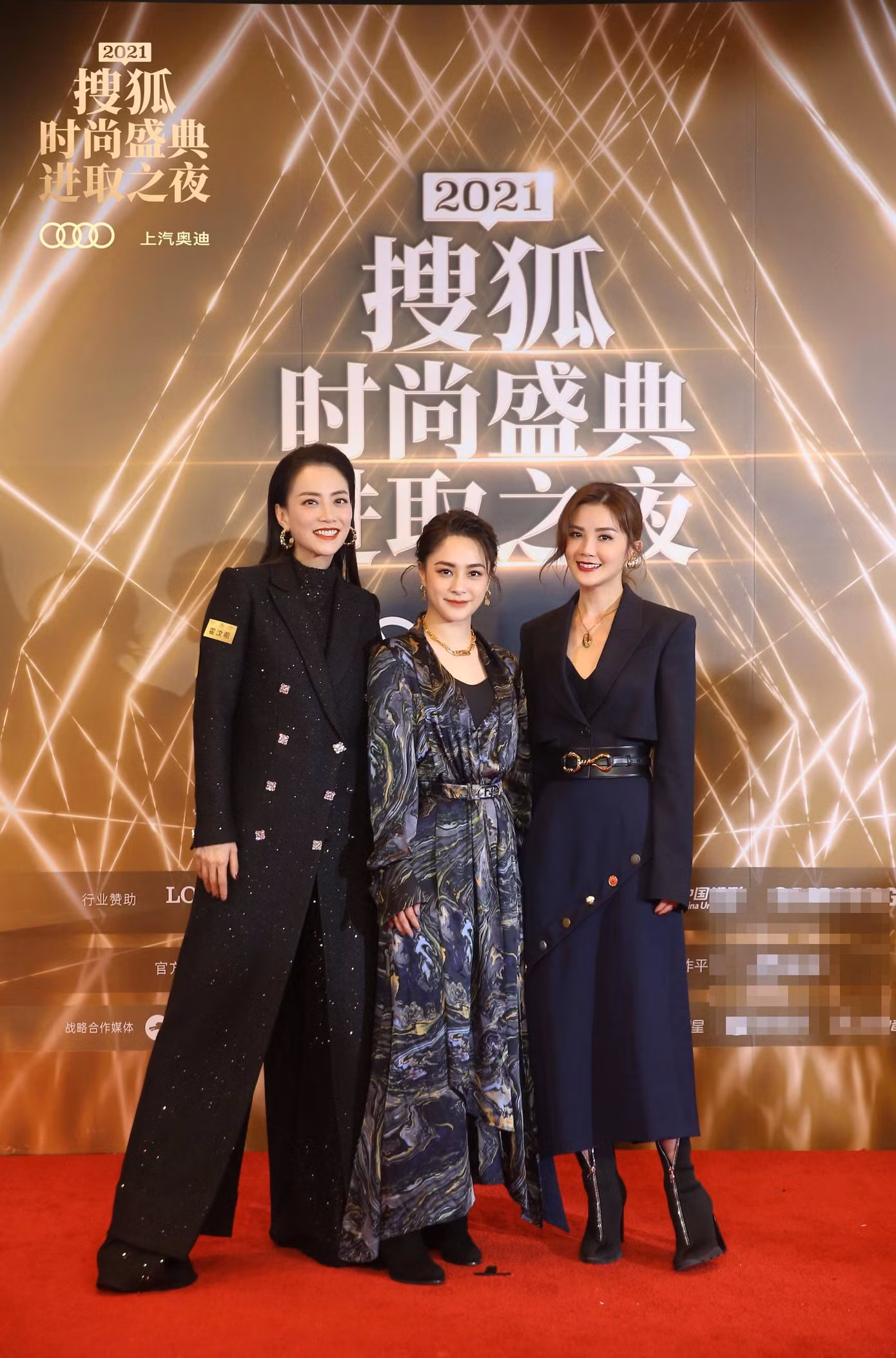 Hai thành viên nhóm nhạc Twins Chung Hân Đồng (giữa) và Thái Trác Nghiên (phải) đi thảm đỏ cùng nhà sản xuất phim Mani Fok.