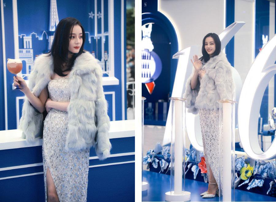 Tại sự kiện, Nhiệt Ba diện đầm bạc xẻ tà, khoác thêm áo lông màu xám và đi đôi giày cao gót "ton-sur-ton" với trang phục.