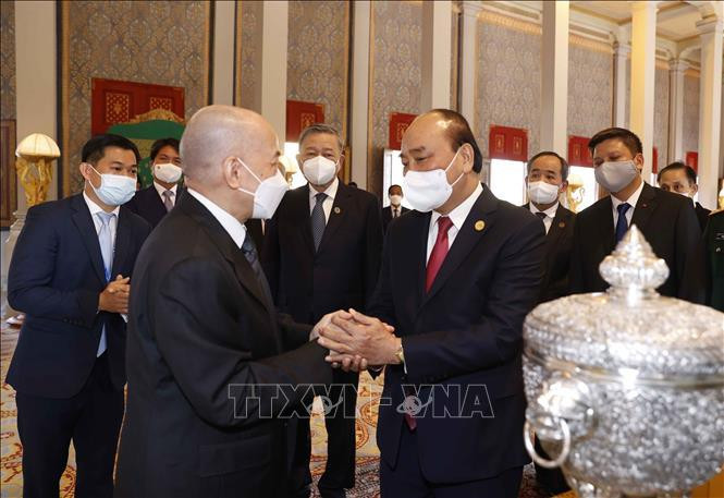 Chủ tịch nước Nguyễn Xuân Phúc và Quốc vương Campuchia Norodom Sihamoni giới thiệu về quà tặng của hai nước tại Cung điện Hoàng gia. Ảnh: Thống Nhất/TTXVN