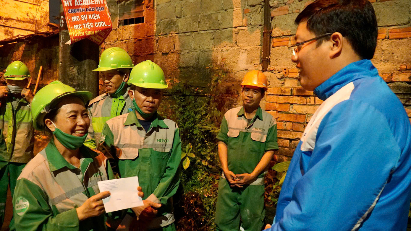 Nụ cười đầy xúc động của nữ công nhân môi trường tại Huế như xua đi những vất vả, mệt mỏi trong ngày làm việc cuối năm.