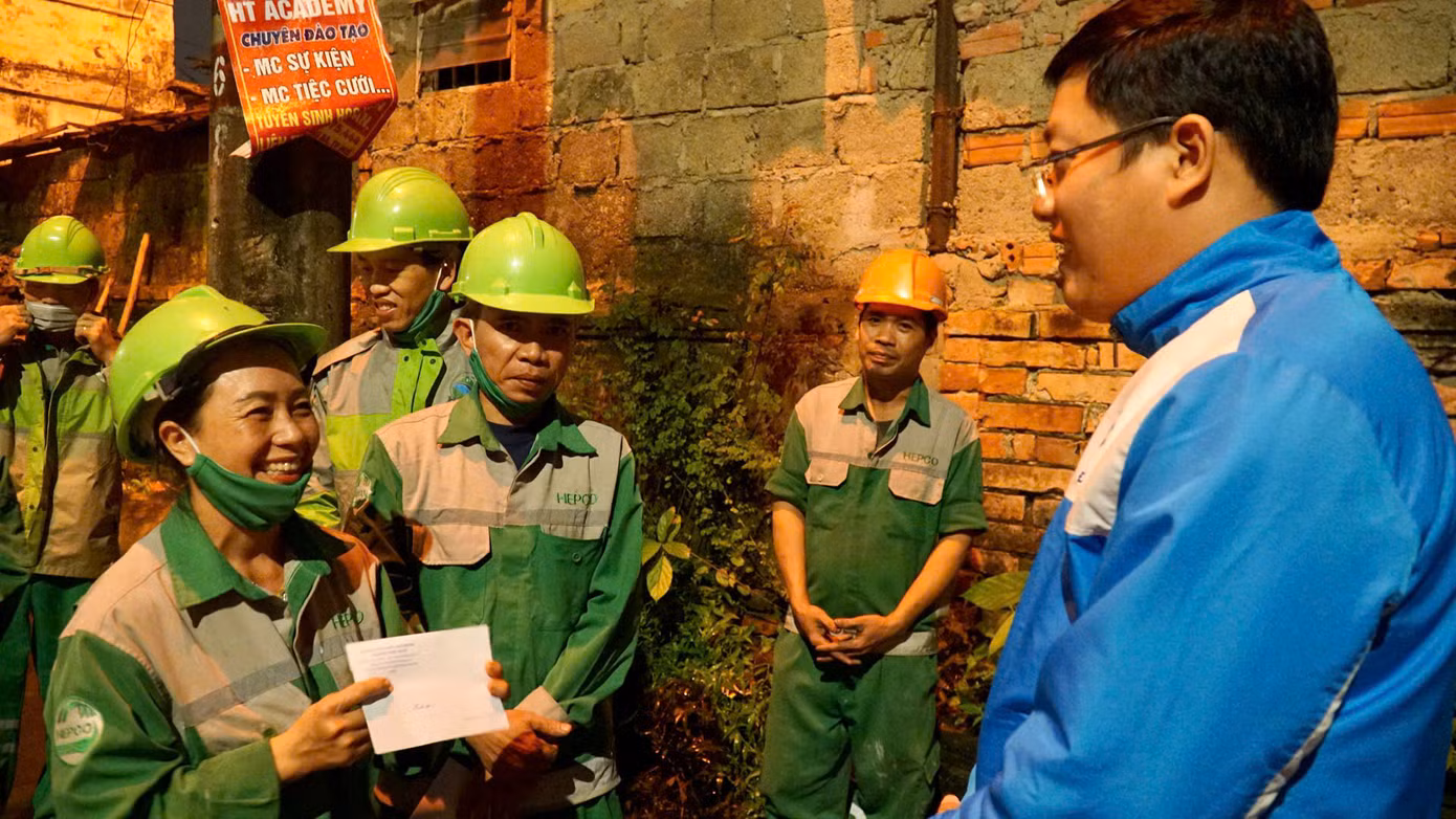 Nụ cười đầy xúc động của nữ công nhân môi trường tại Huế như xua đi những vất vả, mệt mỏi trong ngày làm việc cuối năm.