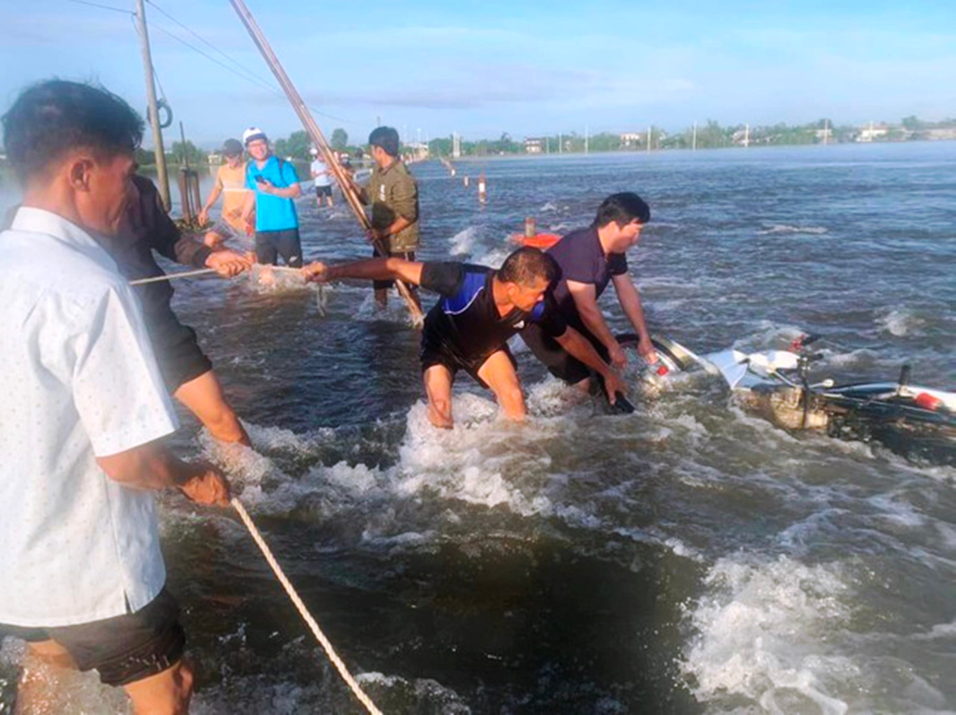 Lực lượng chức năng tiến hành cứu hộ người gặp nạn và trục vớt xe gắn máy bị cuốn trôi đưa lên bờ an toàn. Ảnh: CTV