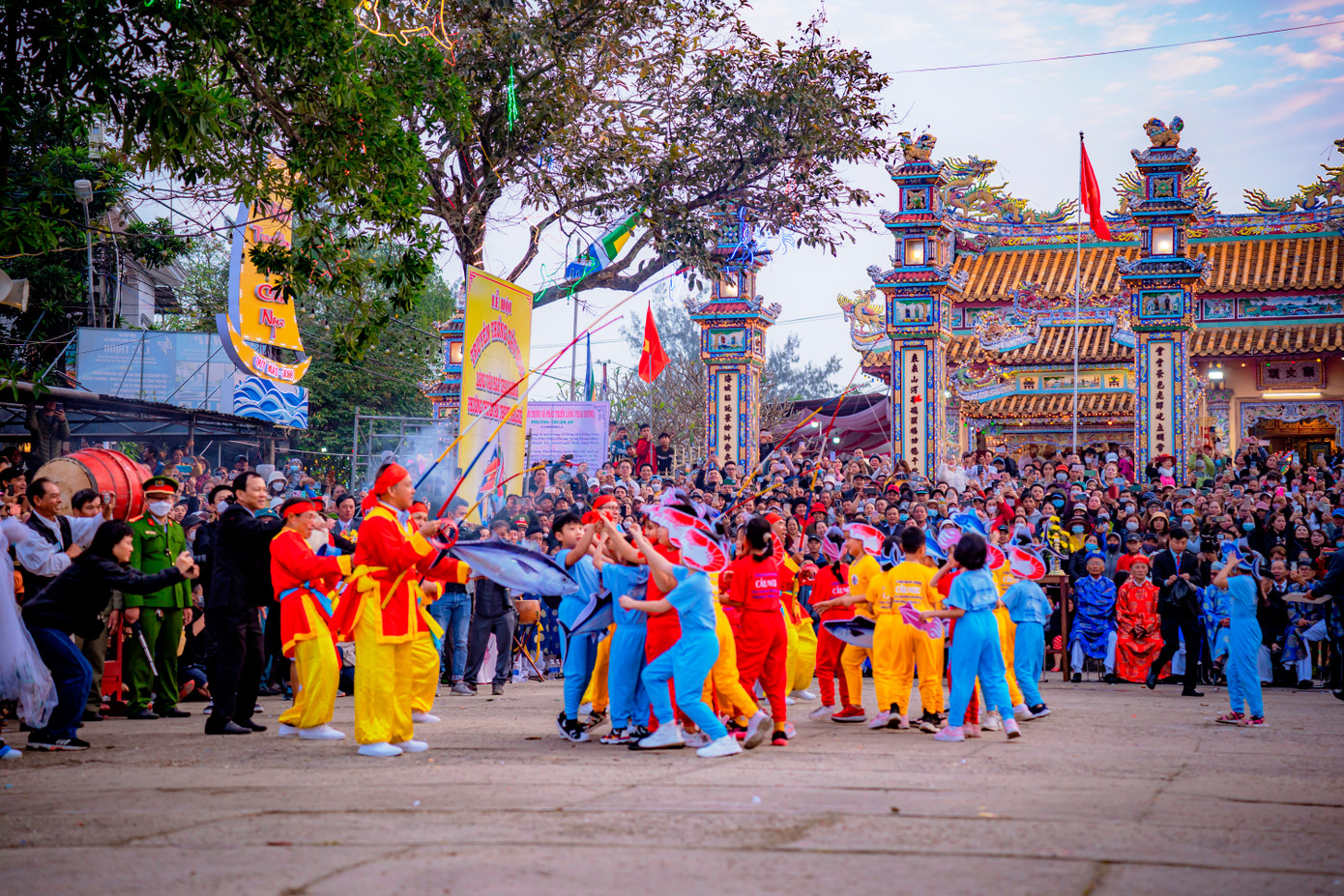 Tại phần hội, các bô lão tung tiền và phẩm vật xuống sân đình cho các em bé hóa trang thành loài cá, mực, tôm... lượm tiền. Ảnh: Đình Hoàng