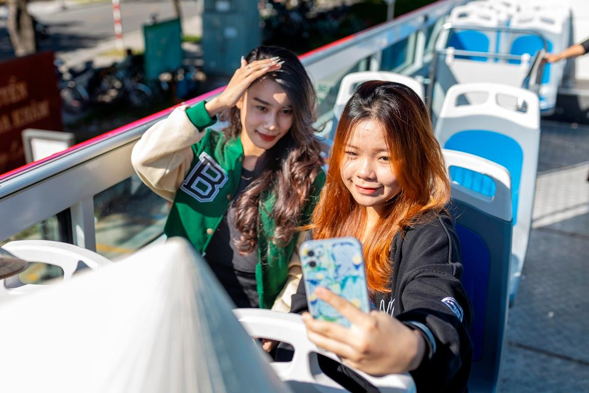 Du khách thích thú trải nghiệm dịch vụ xe buýt du lịch 2 tầng thoáng nóc lần đầu triển khai tại Huế. Ảnh: Sở DL