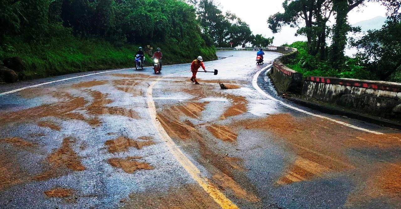 Lực lượng chức năng phủ cát tại nhiều vị trí dầu loang để chống trượt ngã cho xe máy qua phía bắc đèo Hải Vân. Ảnh: CTV