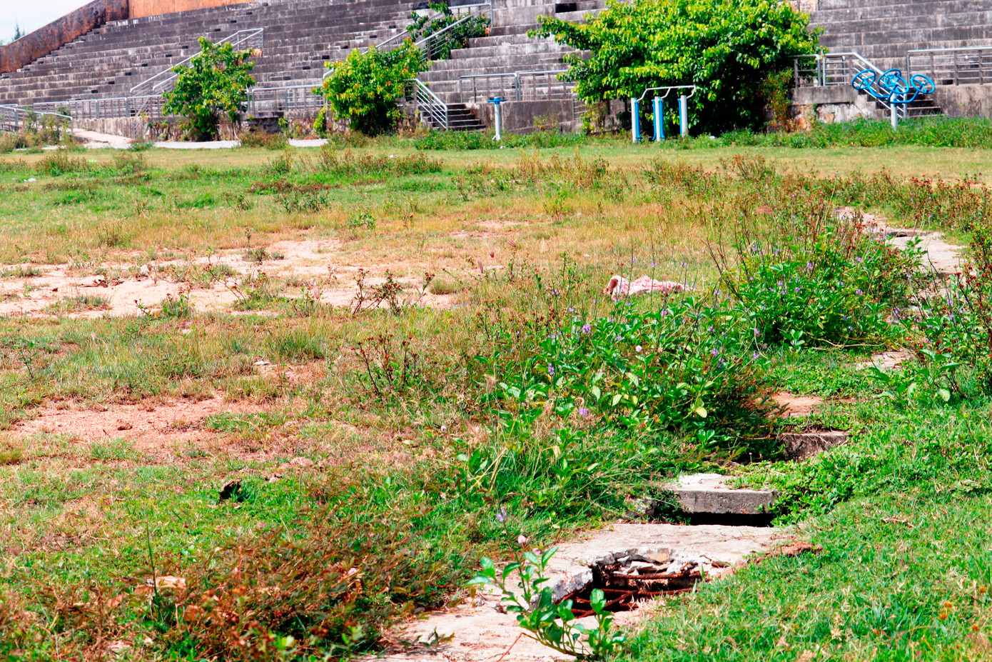 Mặt lát thuộc hệ thống thoát nước bao quanh mặt sân bị hỏng nát, tạo những hố sâu nguy hiểm. Đường bê tông bao quanh sân lu lấp cỏ dại.