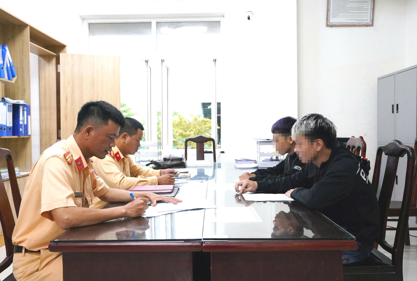 Cảnh sát giao thông làm việc, lấy lời khai đối với hai thiếu niên chạy xe mô tô bằng một bánh. Cảnh sát giao thông làm việc, lấy lời khai đối với hai thiếu niên chạy xe mô tô bằng một bánh.