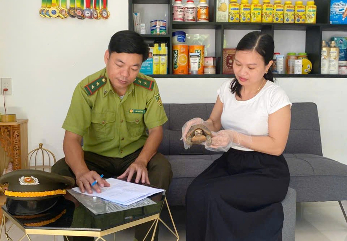 Cán bộ kiểm lâm làm thủ tục tiếp nhận cá thể rùa núi vàng từ bà Nguyễn Thị Thùy Dung.