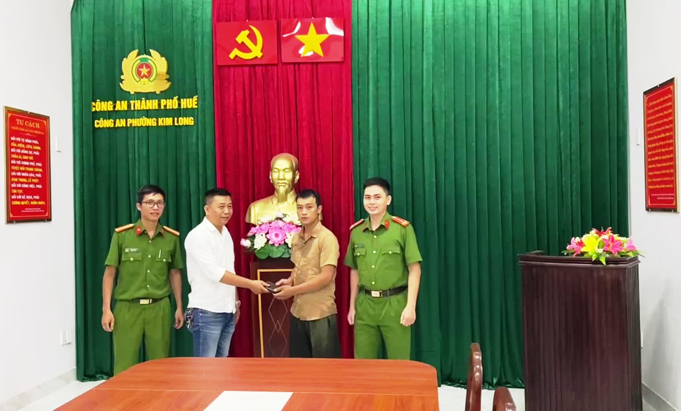 Công an phường Kim Long tiến hành thủ tục trao trả tài sản cho nhân viên giao hàng đánh rơi trước đó.