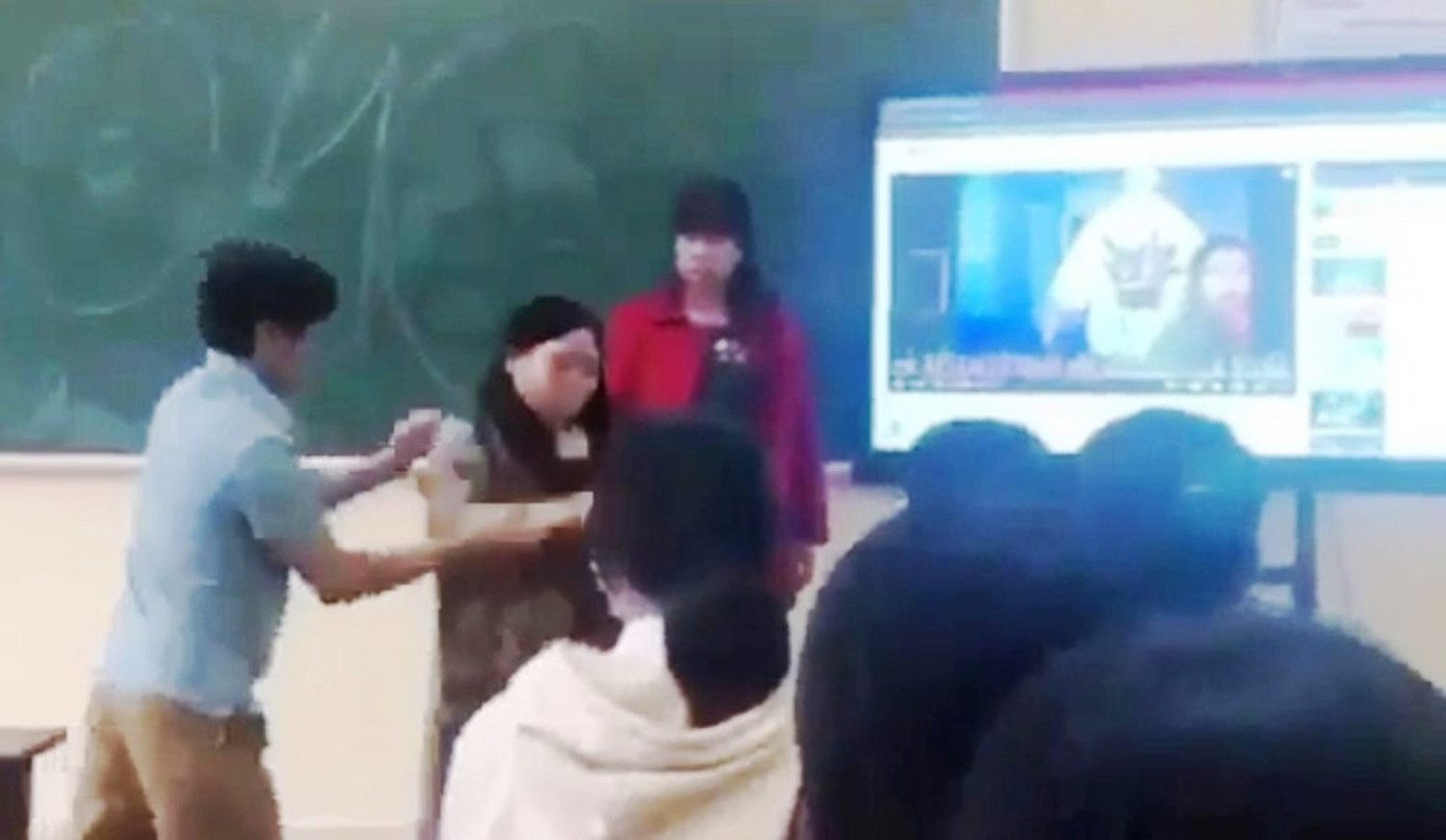 Giáo viên Nguyễn Đức Phong thực hiện hành vi xô đẩy nữ đồng nghiệp ra khỏi lớp trước sự chứng kiến của nhiều học sinh. (Ảnh cắt từ clip).