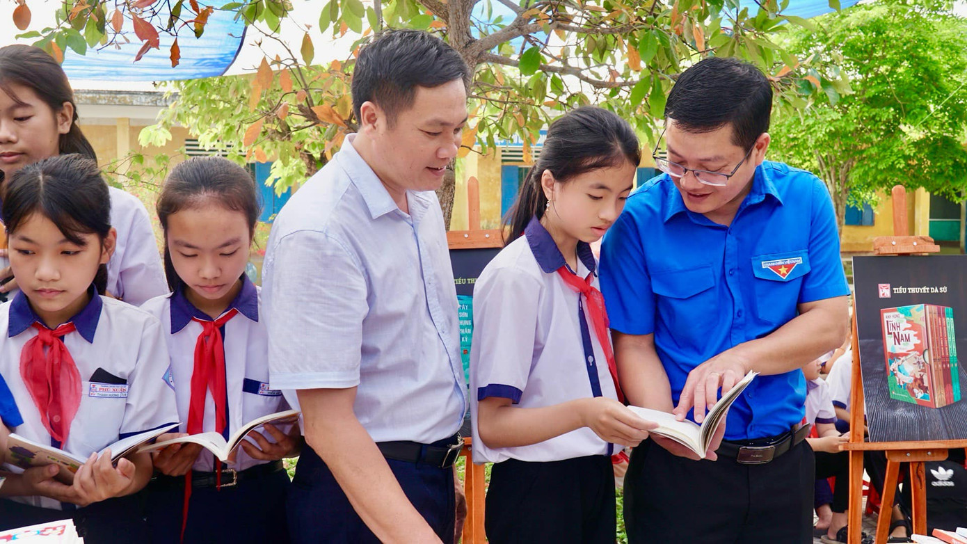 Anh Nguyễn Thanh Hoài (bìa phải) - Bí thư Tỉnh Đoàn TT-Huế, chia sẻ niềm đam mê đọc sách đến học sinh Trường THCS Phú Xuân, huyện Phú Vang.