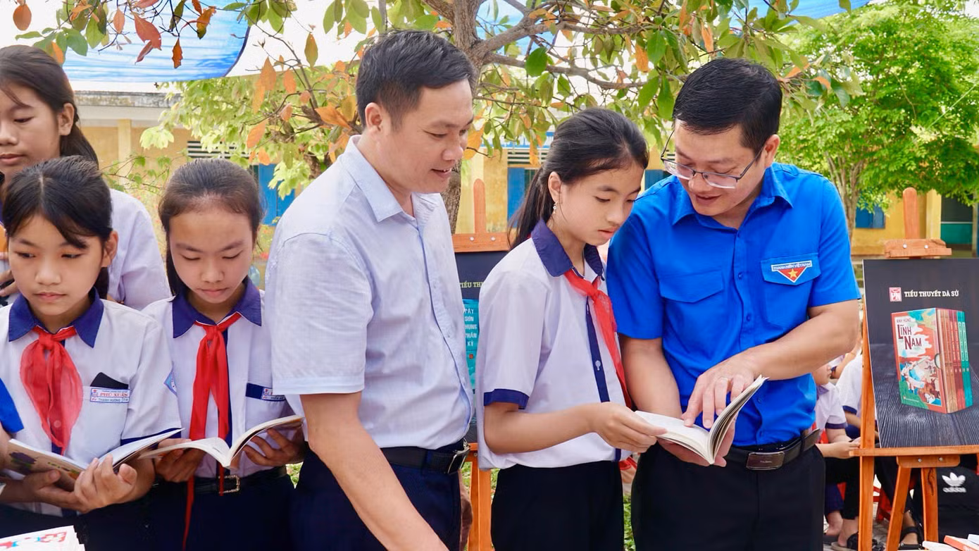 Anh Nguyễn Thanh Hoài (bìa phải) - Bí thư Tỉnh Đoàn TT-Huế, chia sẻ niềm đam mê đọc sách đến học sinh Trường THCS Phú Xuân, huyện Phú Vang.