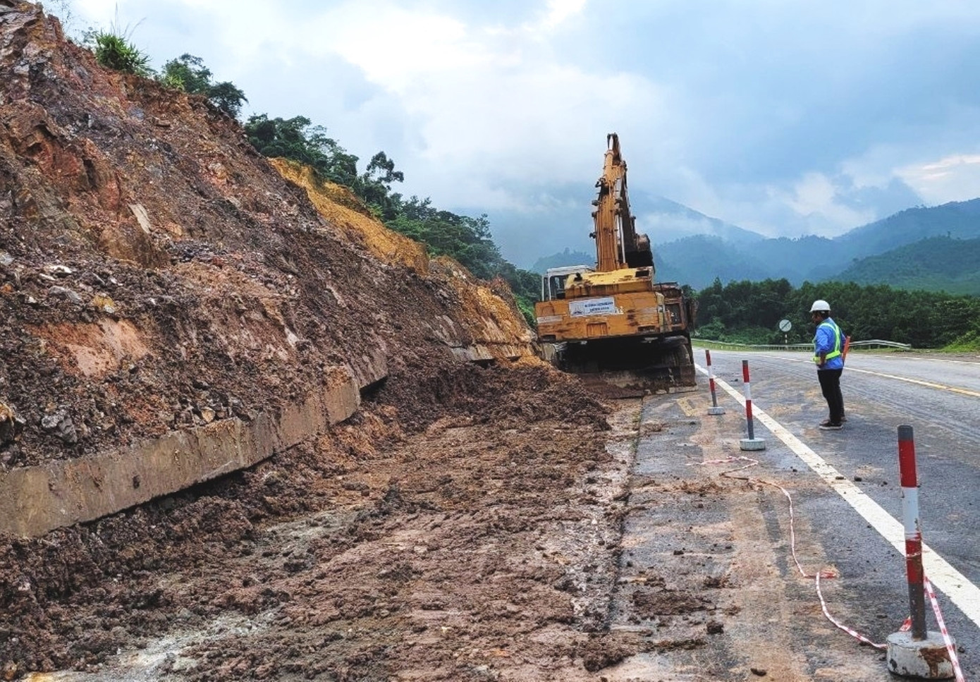 Xử lý đất đá sạt lở do mưa lớn đổ xuống đường cao tốc La Sơn - Túy Loan. (Ảnh: CTV)