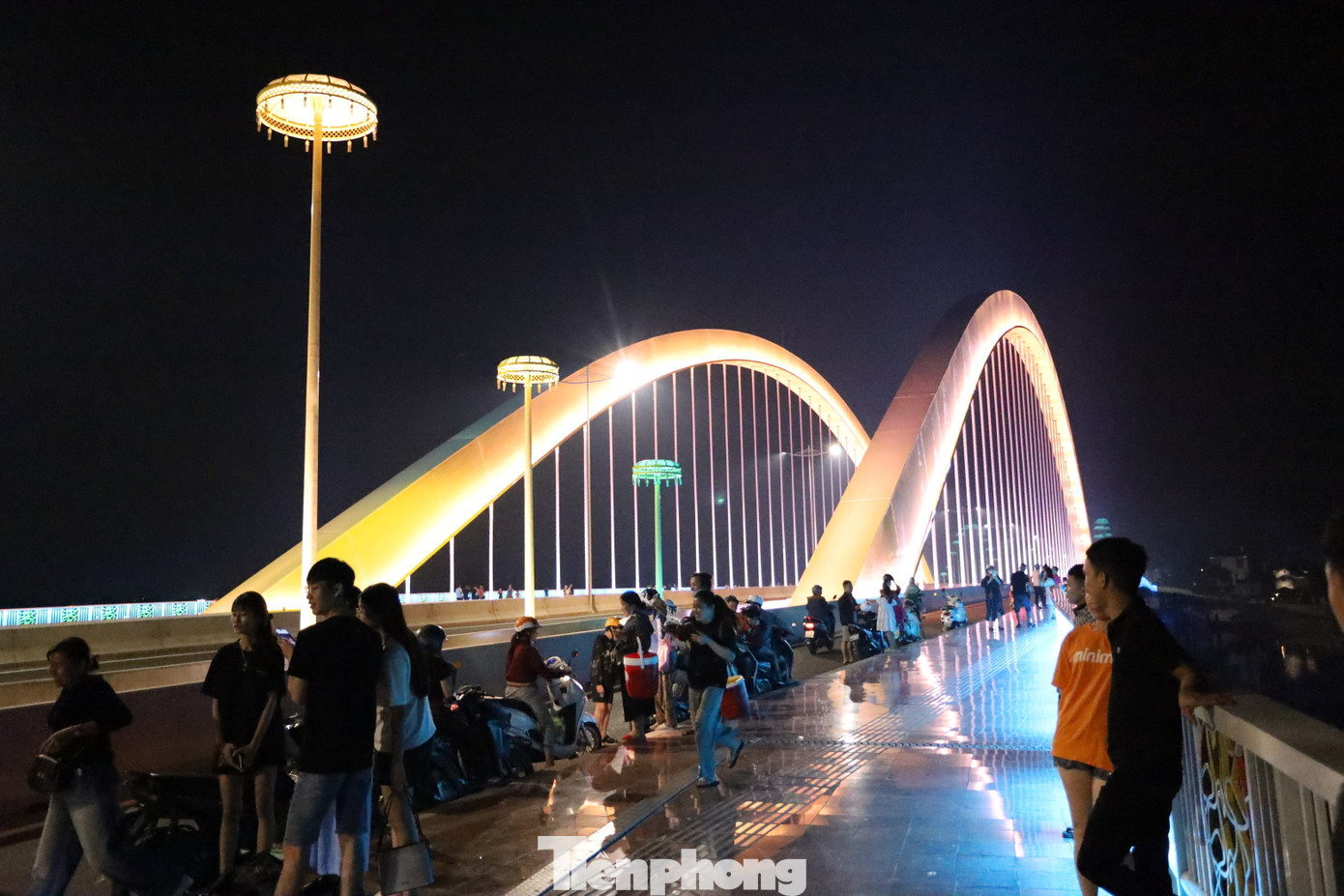 Những nhóm bạn trẻ trò chuyện rôm rả bên lan can cầu, các cặp đôi nắm tay nhau tản bộ, những em nhỏ vui đùa dưới ánh đèn lung linh.