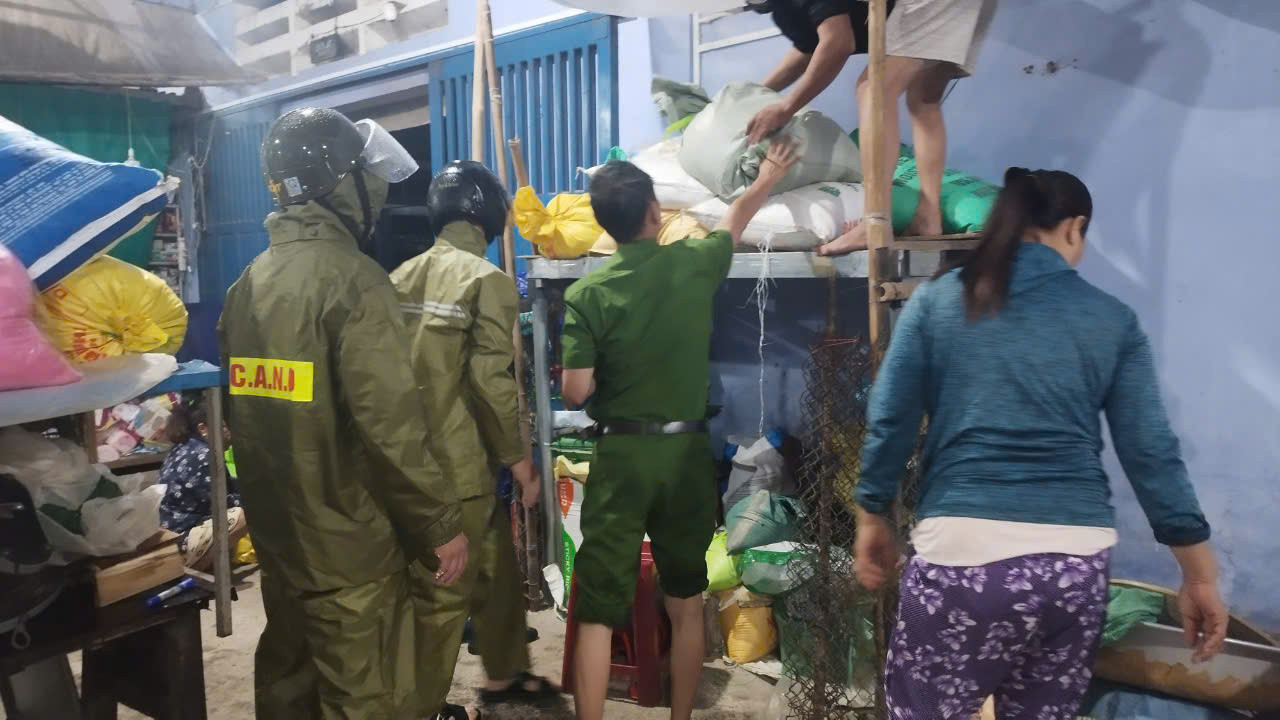 Lực lượng chức năng hỗ trợ người dân tập kết tài sản, lương thực lên chỗ khô ráo.