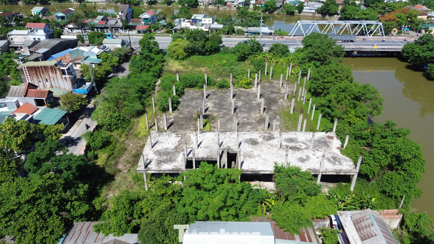 Tại hiện trường, hàng chục trụ bê tông phơi lõi thép gỉ sét, cỏ dại mọc um tùm, vật liệu xây dựng nằm ngổn ngang, tường gạch trơ vữa, nước đọng nhiều nơi, gây ô nhiễm môi trường nghiêm trọng. Bao quanh khu vực là hàng rào tôn xiêu vẹo, mục gỉ tuềnh toàng, dây leo chằng chịt... như một lời nhắc về sự trì trệ kéo dài của dự án tiền tỷ.