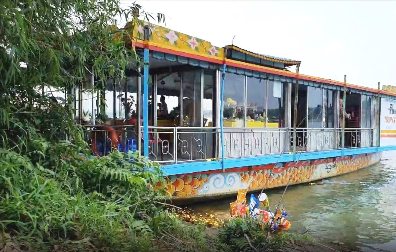Người trên thuyền rồng này có hành vi thả vàng mã trái phép xuống nguồn nước tự nhiên của sông Hương. Ảnh: Hue-S