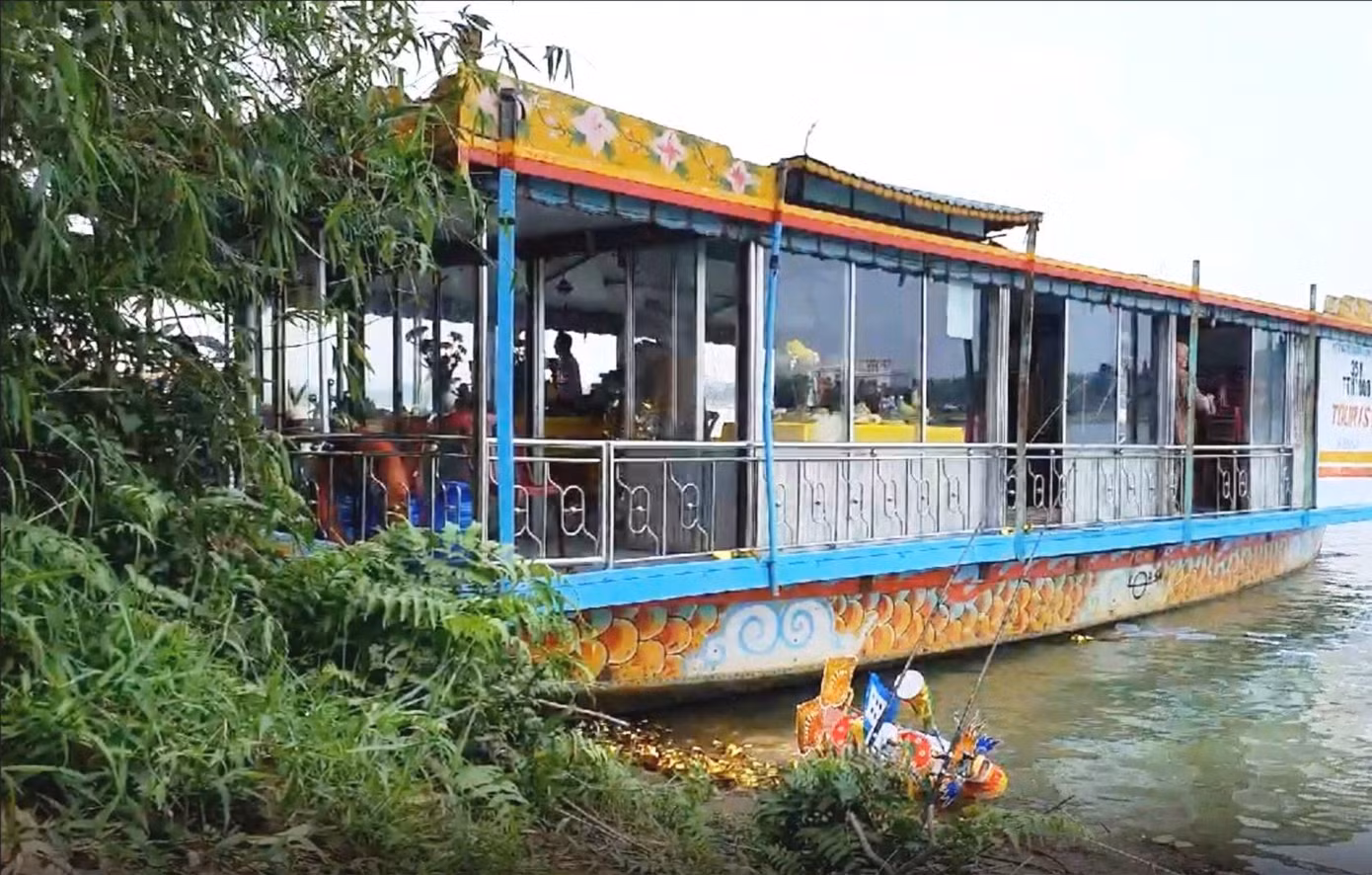 Người trên thuyền rồng này có hành vi thả vàng mã trái phép xuống nguồn nước tự nhiên của sông Hương. Ảnh: Hue-S