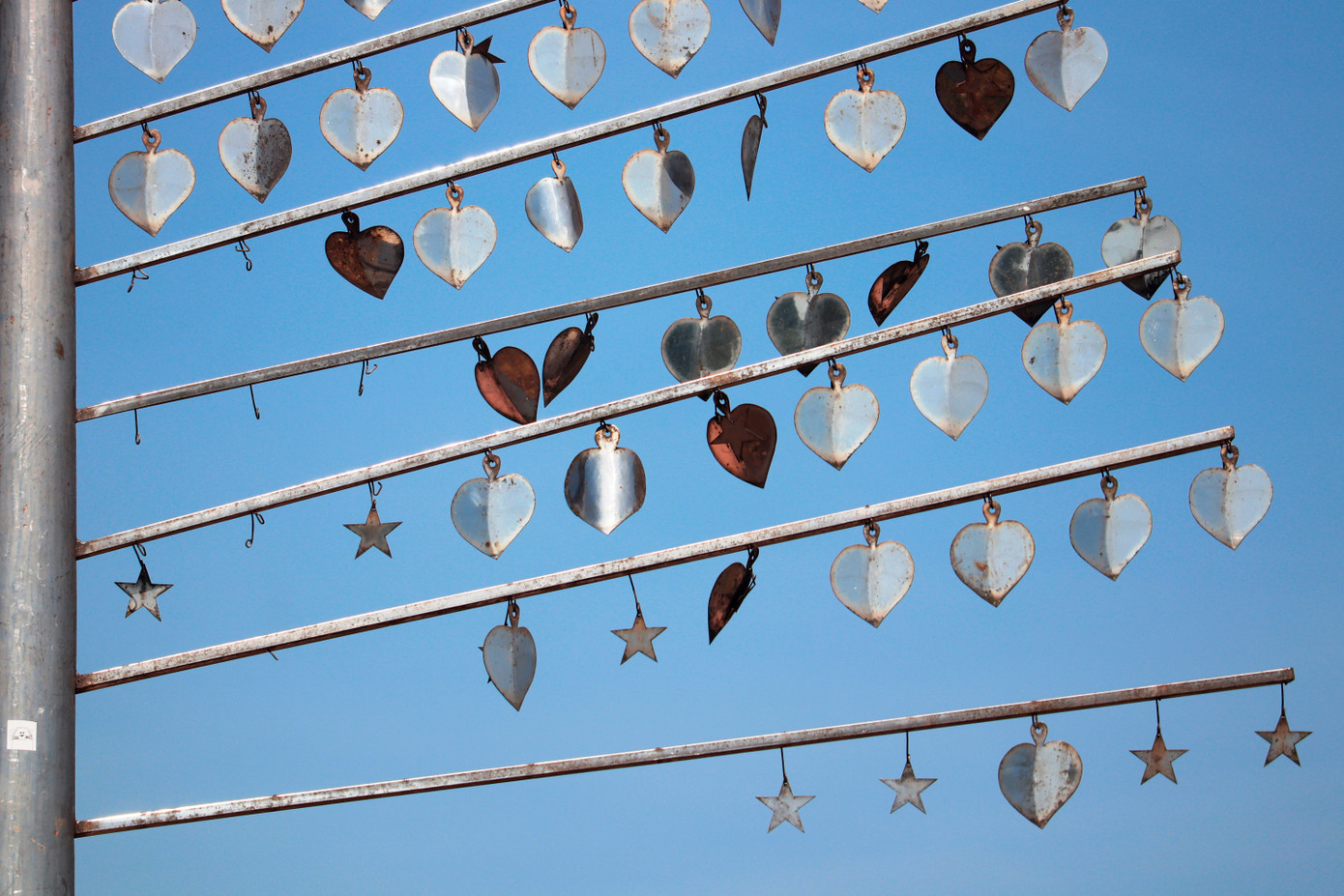 Những trái tim, ngôi sao bằng kim loại gắn trên các thanh inox tủa ra hai bên theo hình chiếc lá của tác phẩm “Melody of Friendship” đã rơi rụng dần.