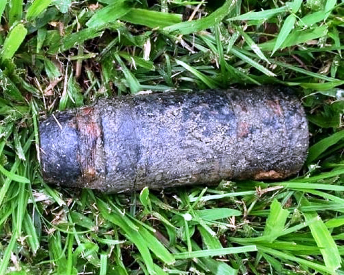 Đầu đạn pháo 100mm được phát hiện trên bãi cỏ ven sông Hương. Ảnh: CTV