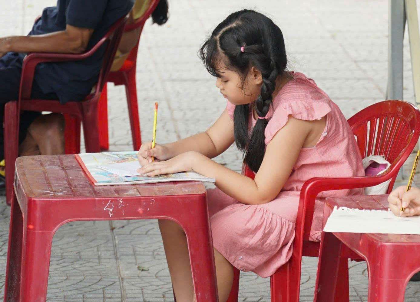 Một "họa sĩ nhí" miệt mài với tác phẩm của mình.