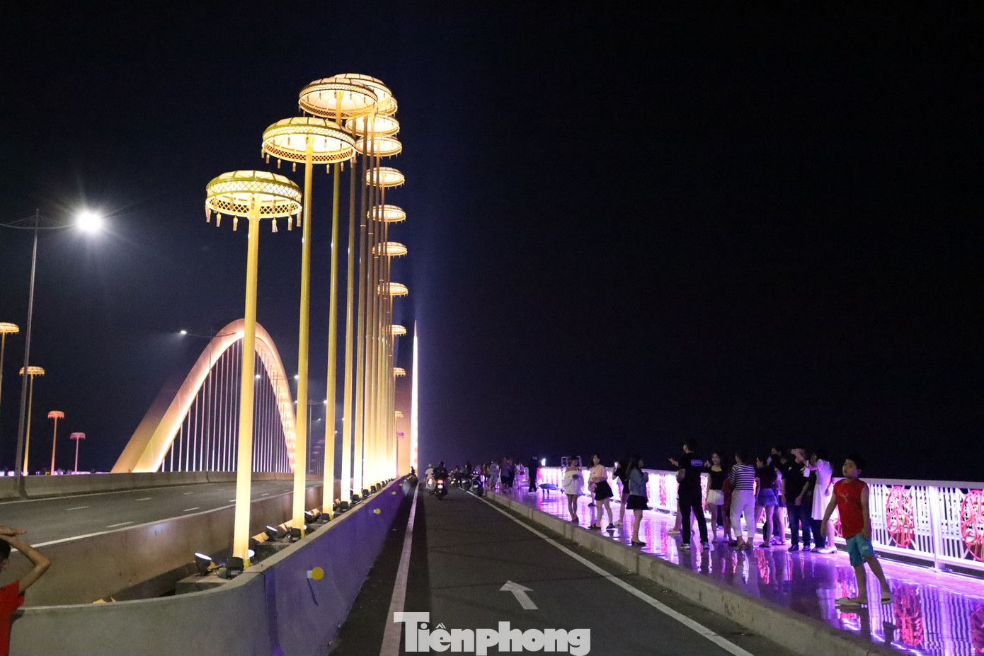 Hệ thống đèn LED công nghệ cao được thiết kế theo từng khu vực, cho phép chuyển đổi hàng trăm sắc màu khác nhau, tạo nên hiệu ứng thị giác ngoạn mục, phản chiếu lung linh trên mặt nước phẳng lặng như gương. Đặc biệt, 60 cột đèn nghệ thuật dọc theo cầu được lấy cảm hứng từ hình ảnh “lọng che vua” trong kiến trúc cung đình Huế. Ánh sáng từ các cột đèn như những chiếc vương miện lấp lánh, vừa trang trọng, vừa huyền ảo.