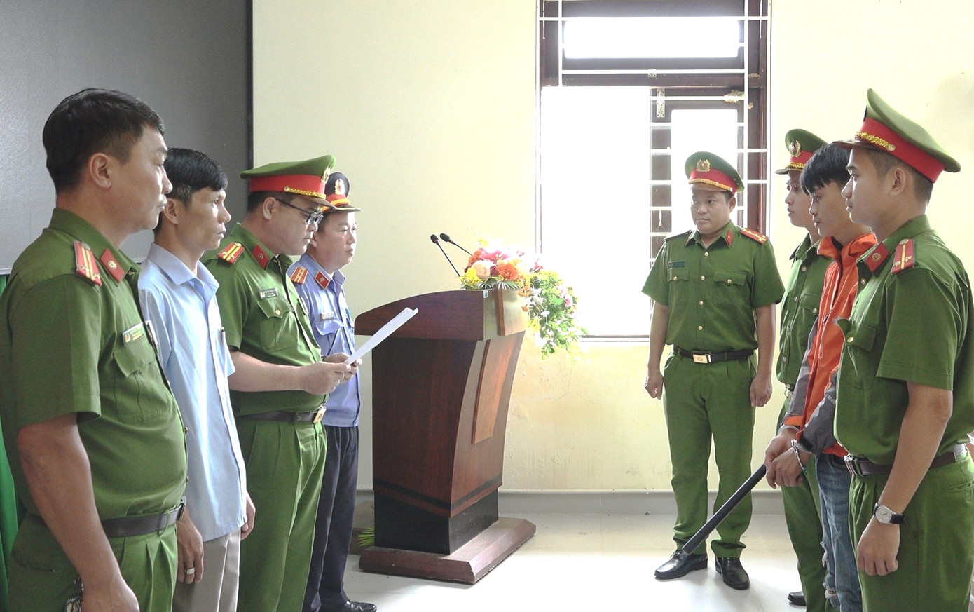Công an đọc lệnh khởi tố, bắt tạm giam đối tượng Nguyễn Phúc (áo đỏ, thứ hai từ phải sang). Ảnh: P.H Công an đọc lệnh khởi tố, bắt tạm giam đối tượng Nguyễn Phúc (áo đỏ, thứ hai từ phải sang). Ảnh: P.H
