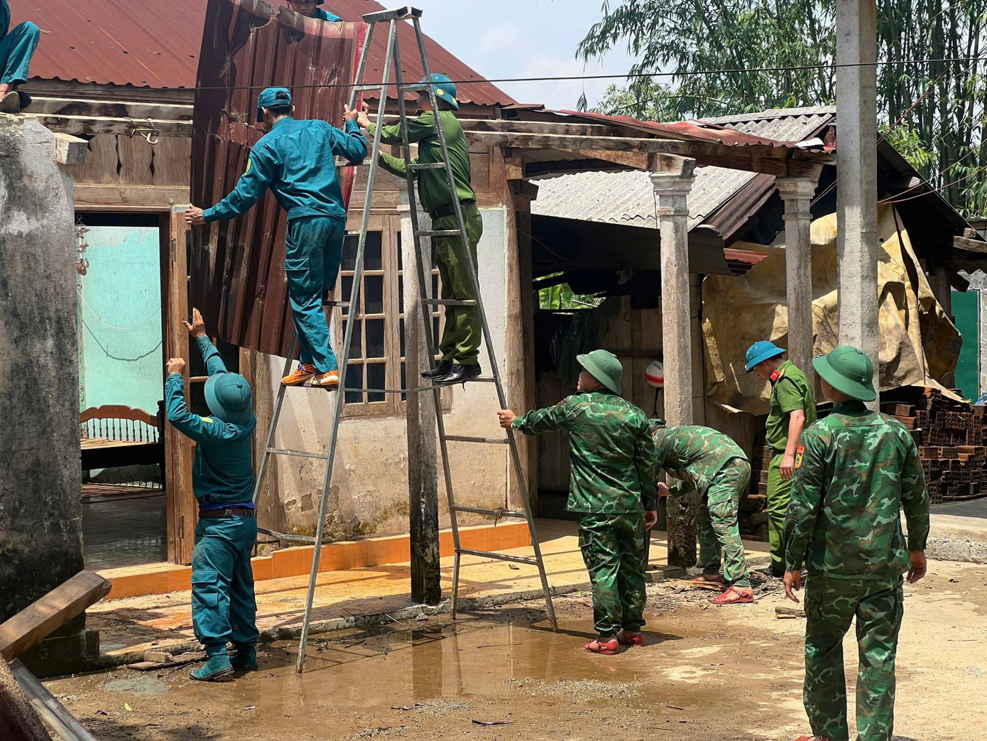 Lực lượng bộ đội hỗ trợ người dân A Lưới khắc phục nhà cửa bị gió lốc cuốn tốc mái.