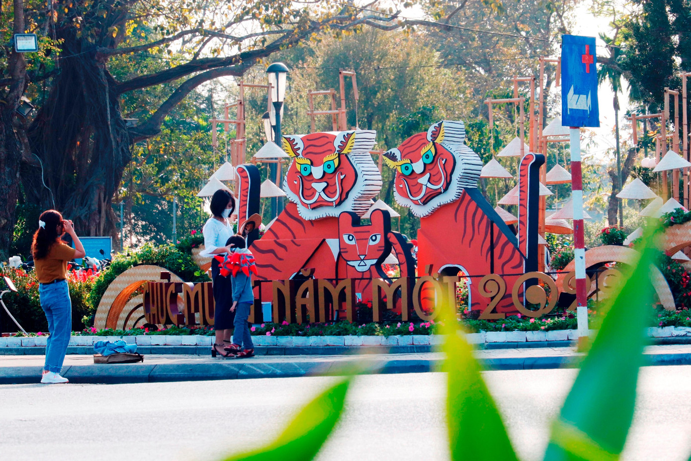 Giới trẻ chụp hình lưu niệm tại cụm linh vật hổ phía nam chân cầu Phú Xuân. Tạo hình hổ ở đây không theo hình khối tròn mà bằng các tấm ghép trang trí phẳng.