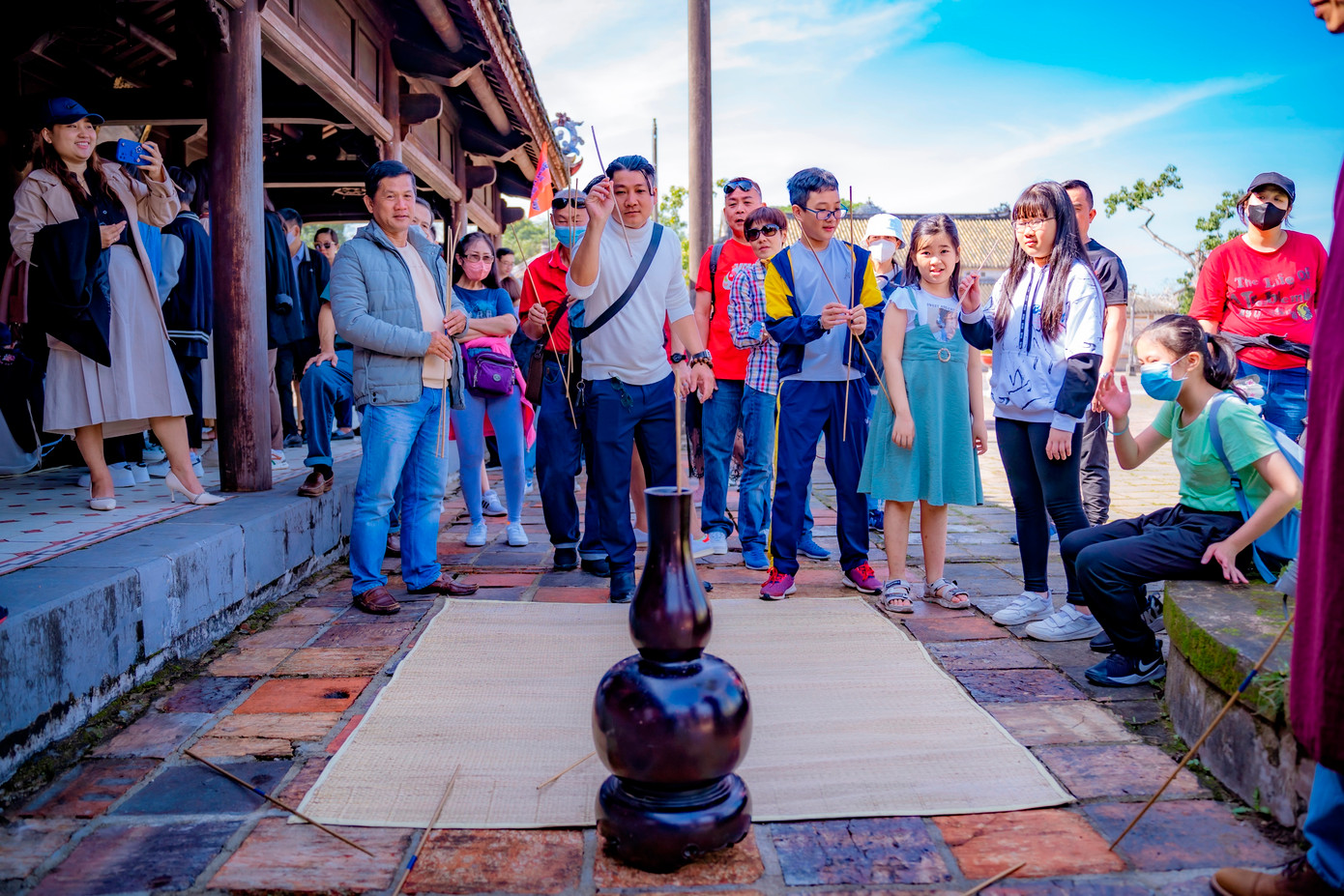 Nhiều người bị cuốn hút bởi trò chơi đầu hồ (một trò chơi dùng tay phóng những chiếc tên dài vào miệng của một cái bình ở xa) diễn ra bên trong Đại nội. Ảnh: Đình Hoàng