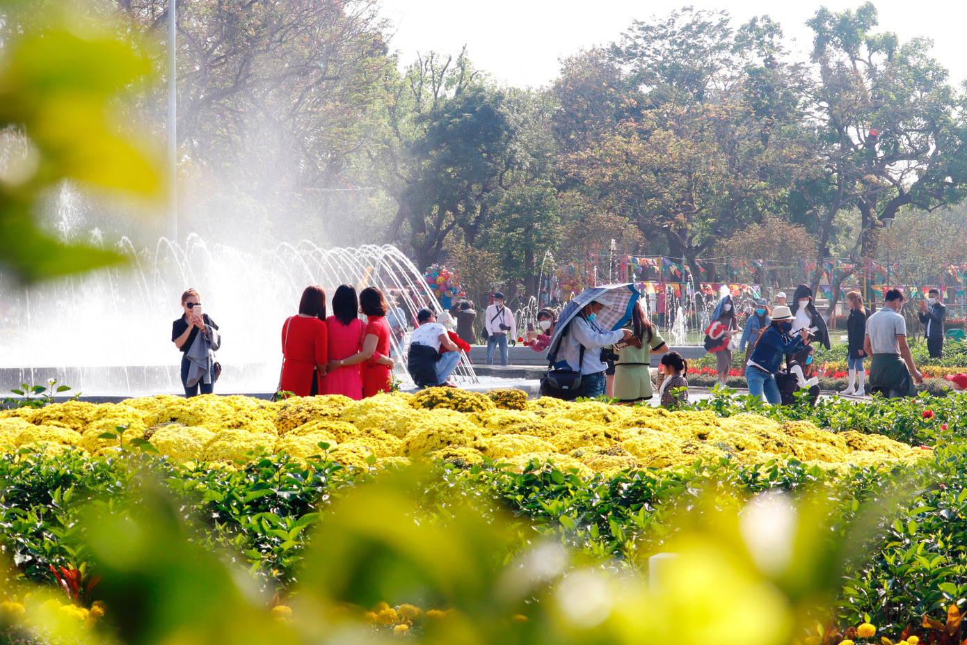 Đông du khách tham quan, chụp ảnh lưu niệm tại khu vực hoa viên và đài phun nước nghệ thuật ven sông Hương chiều mùng 7 Tết