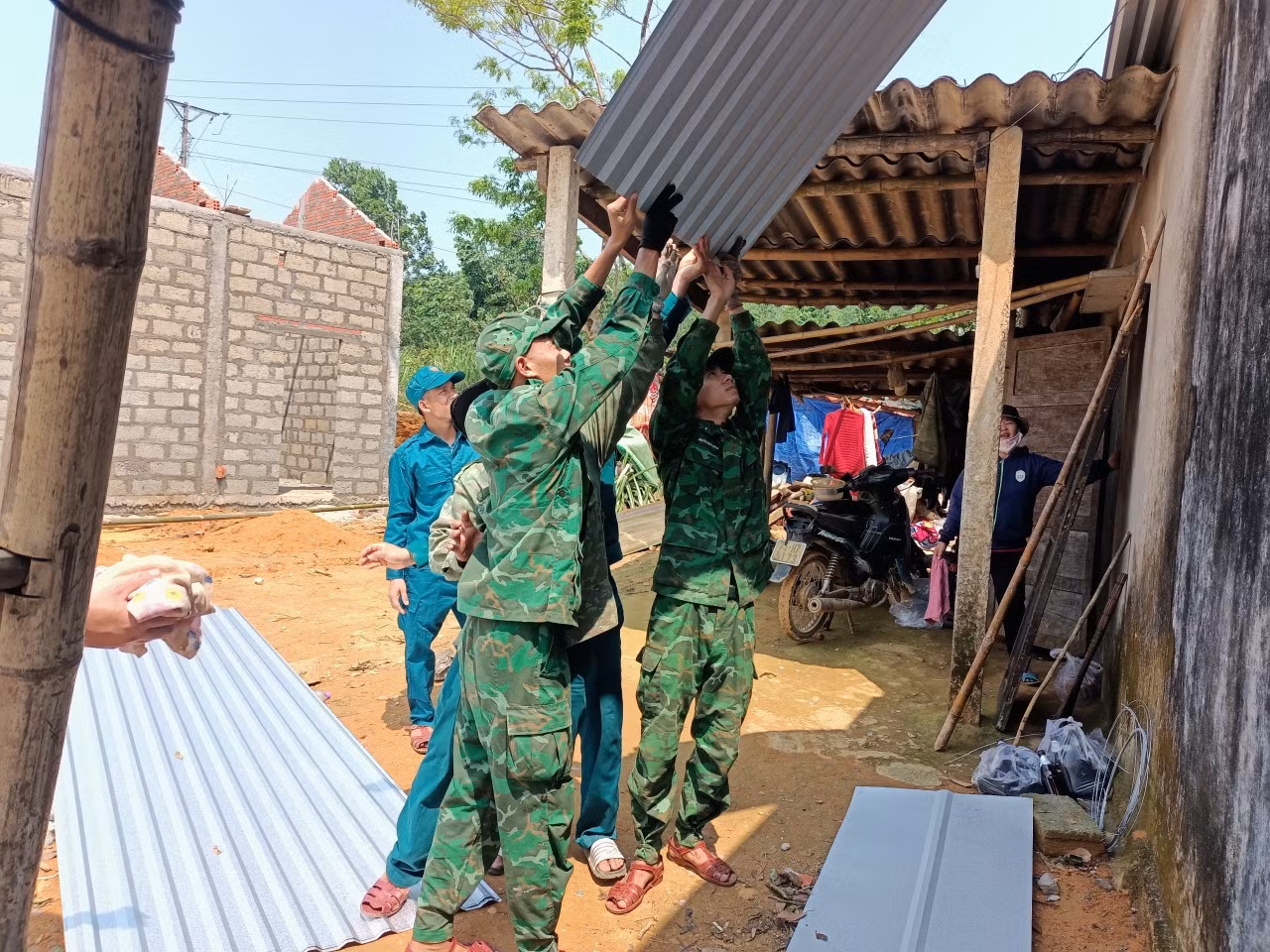 Lực lượng Bộ đội Biên phòng, dân quân, đoàn viên, thanh niên địa phương giúp dân sửa chữa lại nhà cửa do giông lốc tàn phá.