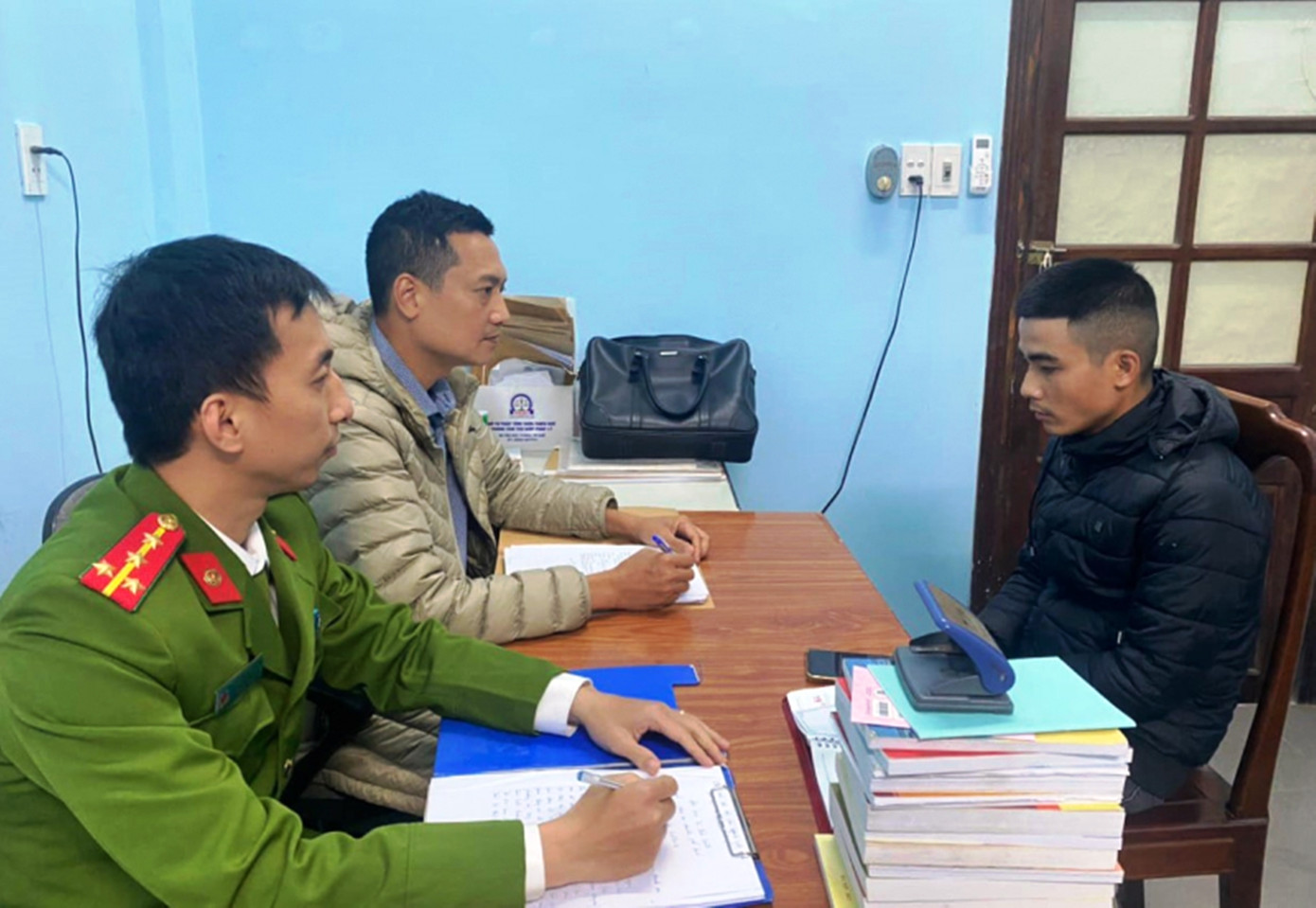 Công an lấy lời khai đối tượng Lê Tuấn Lương (bìa phải). Ảnh: CACC